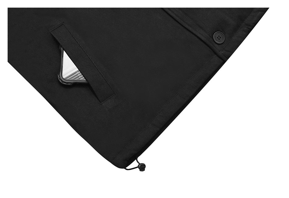 Close-up of a black coat’s slanted pocket with a phone partly visible and an adjustable hem cord.