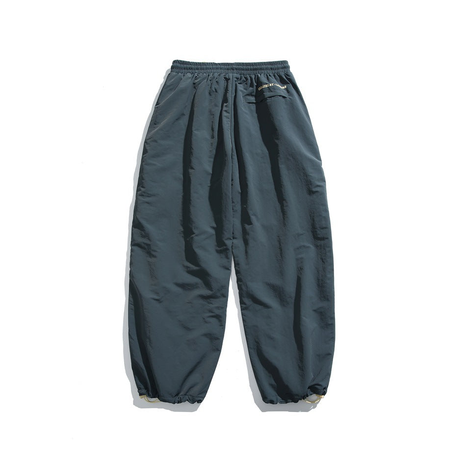 Rear view of slate blue-gray jogger pants with an elastic waist, flap back pocket, and gathered ankle cuffs.