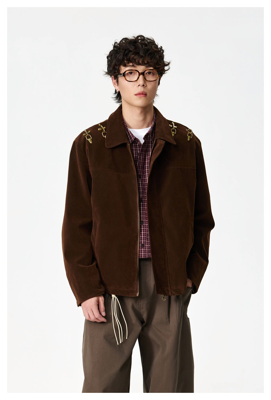 Front view of a model wearing a dark brown jacket with gold shoulder hardware over a burgundy plaid shirt.