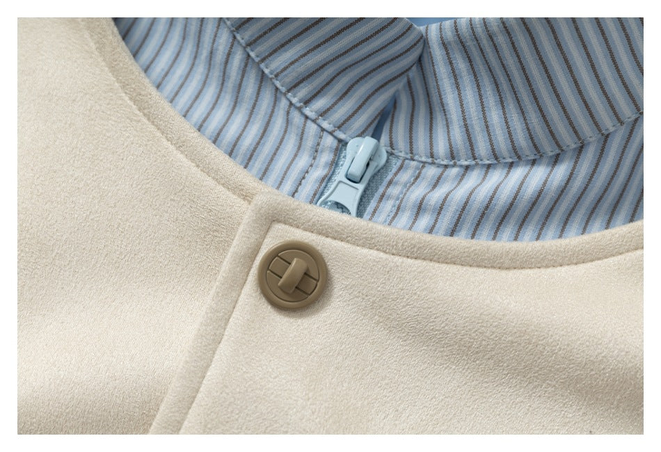 Close-up of a cream garment collar with a tan button and blue striped lining beneath.