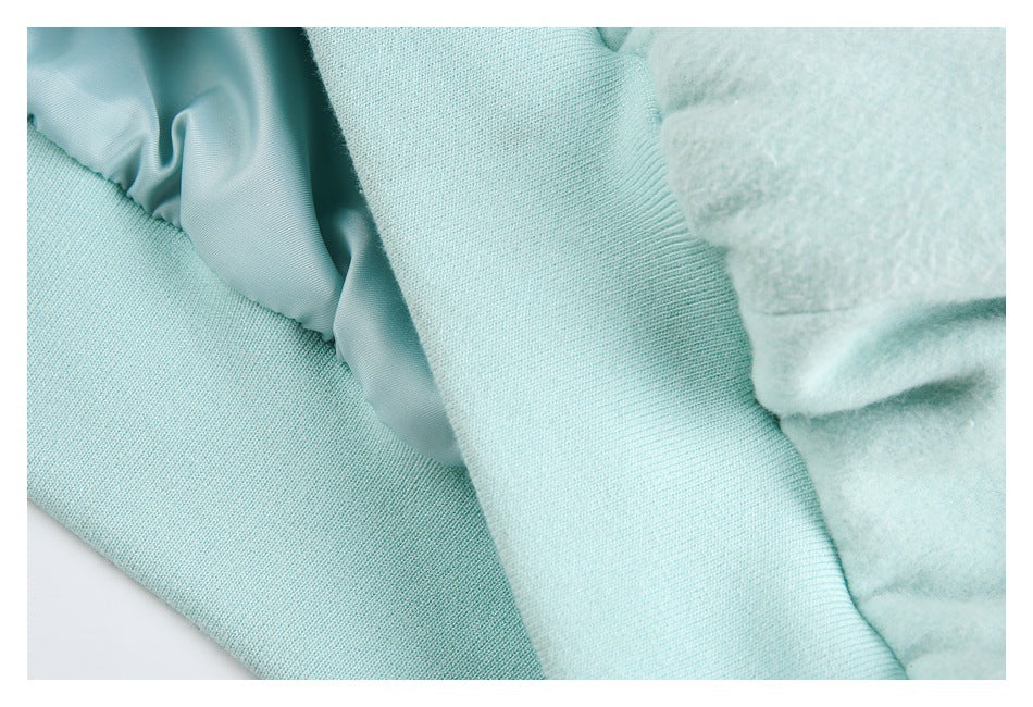 Close-up of pale mint coat lining and seam construction, showing smooth lining beside a fuzzy outer surface.