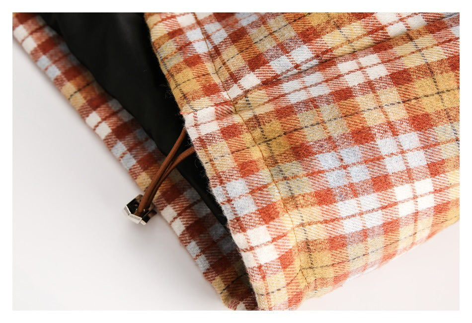 Close-up of the jacket's plaid hem with a brown drawcord and cord toggle.