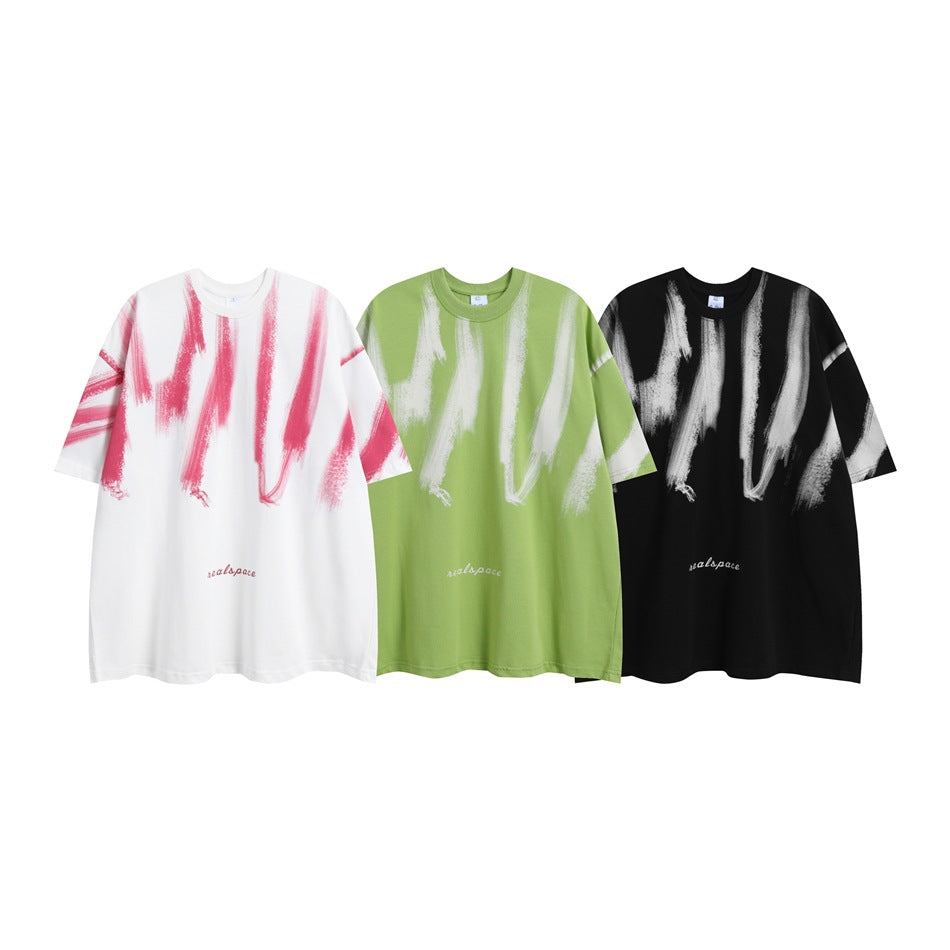 Three oversized brushstroke-print T-shirts shown in white with pink, light green with white, and black with white.