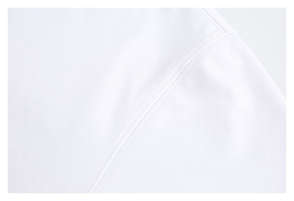 Close-up of white garment fabric showing a curved shoulder seam and stitching.