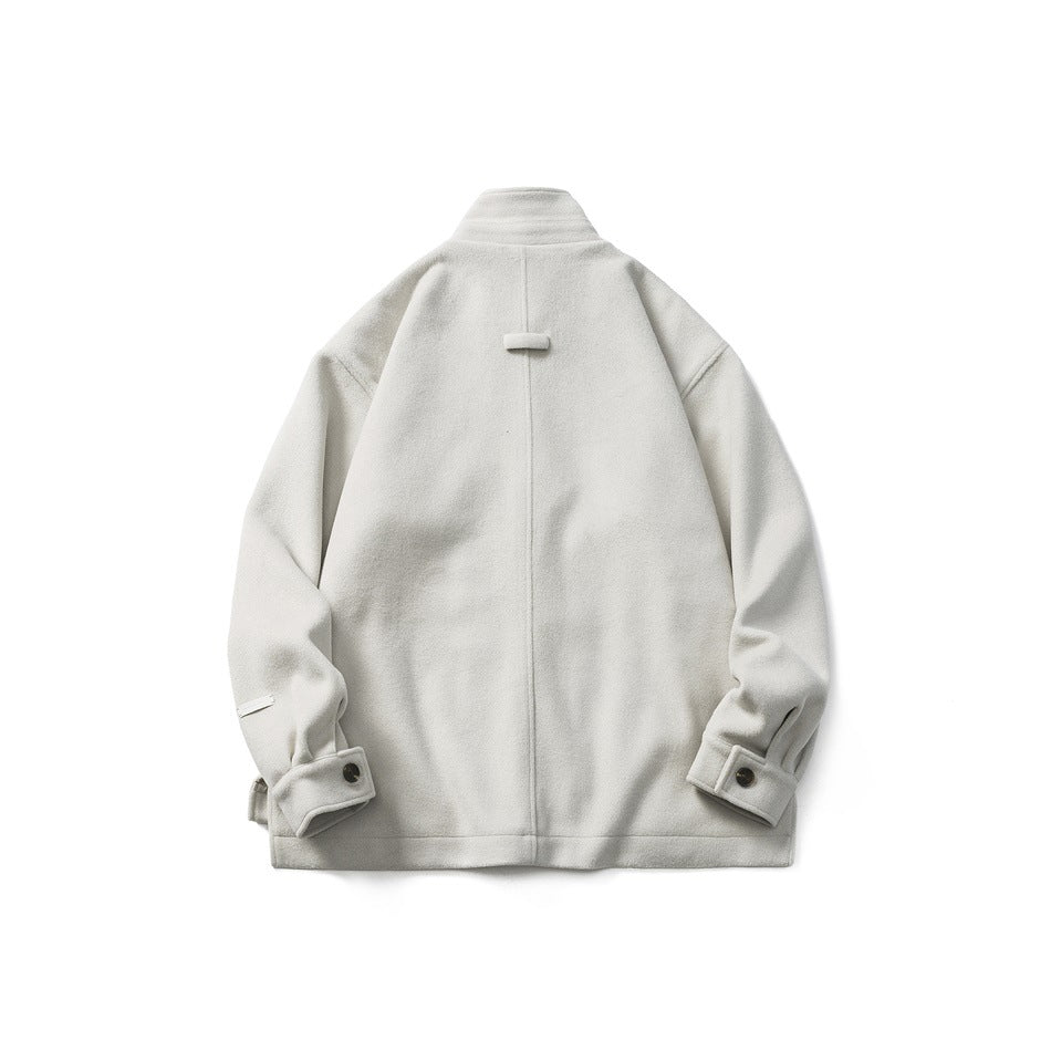 Back view of beige-gray stand-collar jacket with center seam, small back tab and button cuffs, flat lay