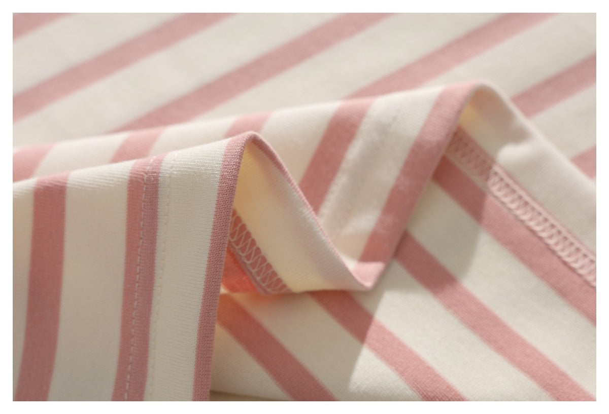 Close-up of pink and cream striped fabric with a folded, overlocked edge.