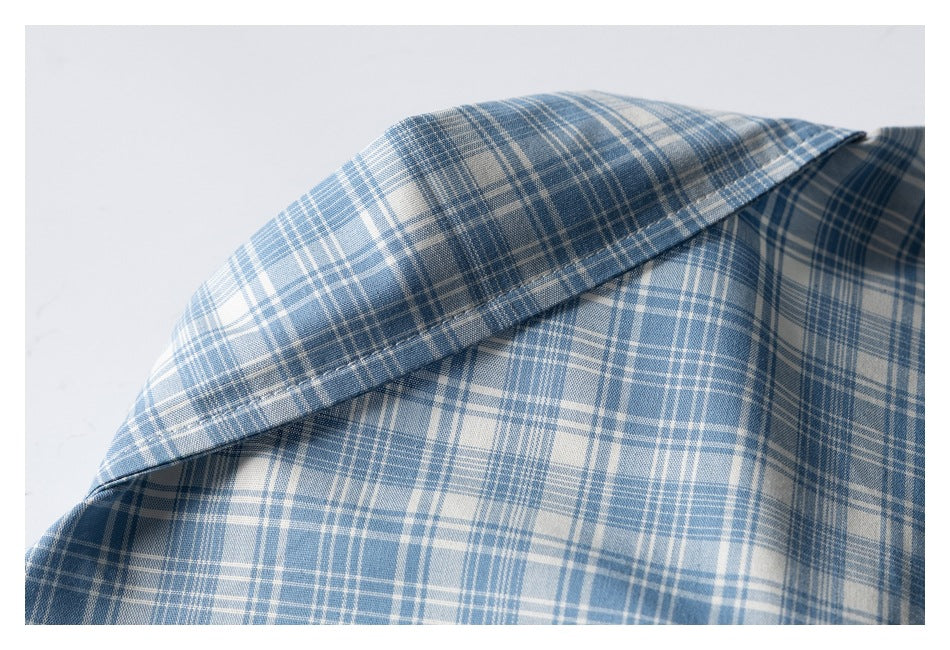 Close-up of the pointed collar on a blue-and-white plaid shirt.