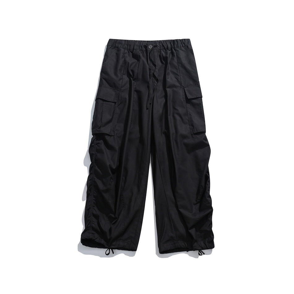 Black wide-leg cargo pants flat lay with elastic waist, drawstring, side flap pockets and drawstring hems