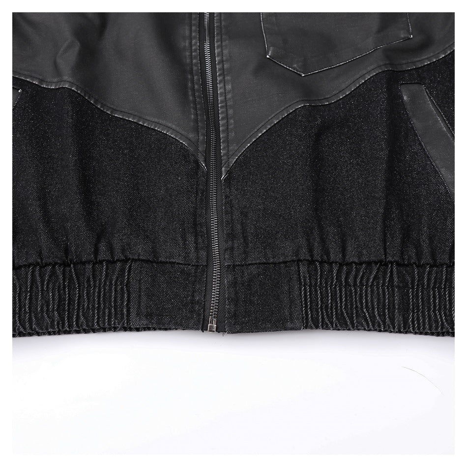 Close-up of a black jacket front with a center zipper, contrasting panels, a pocket edge and gathered hem.