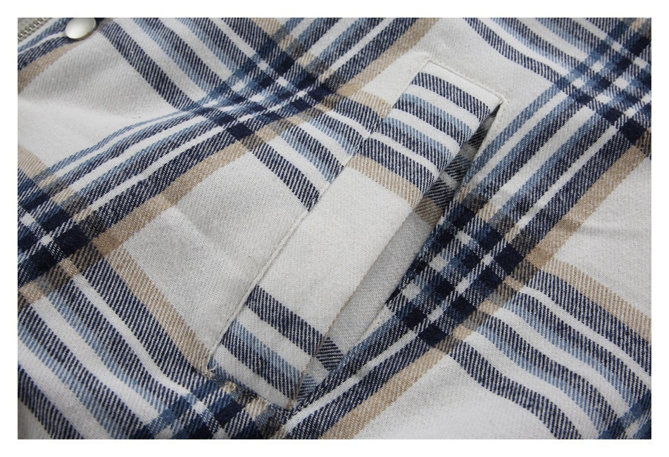 Close-up of a pocket opening on the cream, navy, and tan plaid jacket.