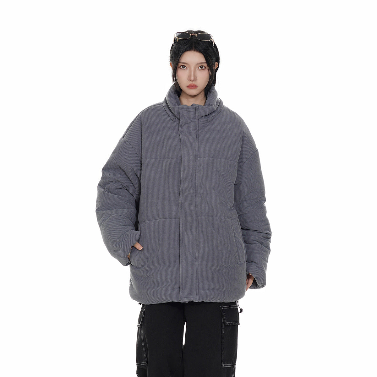 Model wearing a charcoal-gray padded jacket with a tall collar, concealed front closure and large front pockets.