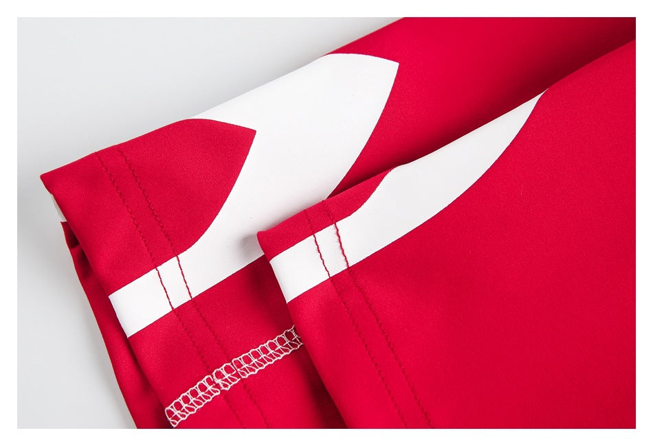 Close-up of two red garment sleeve hems with broad white graphic bands and visible stitching.