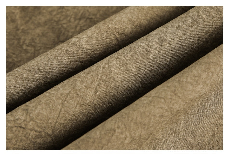 Close-up of taupe-brown mottled fabric folded into diagonal ridges.
