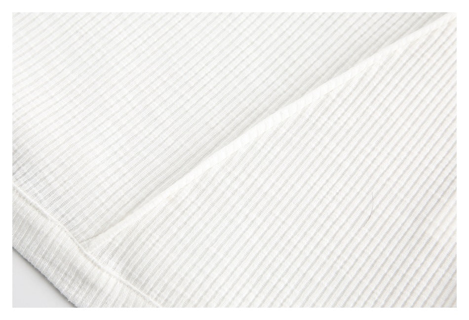 Close-up of the off-white top's narrow ribbed stripes and a diagonal folded seam.