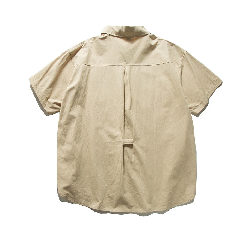 Back view of a beige short-sleeve button-up shirt with a collar and center pleat.