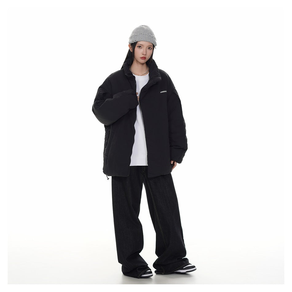 Model wearing an open black padded jacket over a white shirt, with a high collar and oversized sleeves.