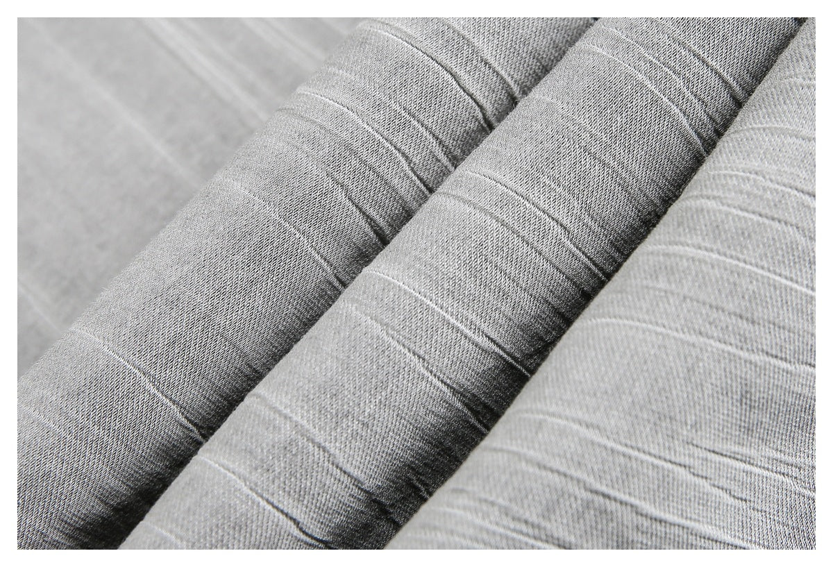 Close-up of gray fabric with narrow woven stripes and stitched seams.