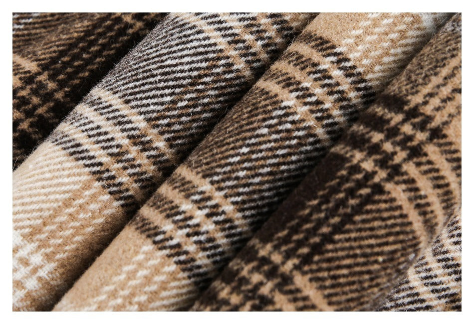 Close-up of folded brown, tan, cream, and black plaid fabric showing its woven texture.