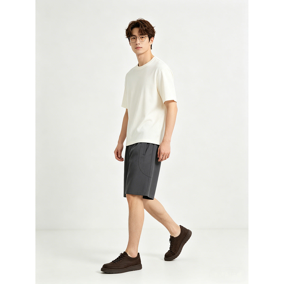 Model wearing a plain white crew-neck T-shirt and charcoal shorts, shown from a three-quarter front angle.