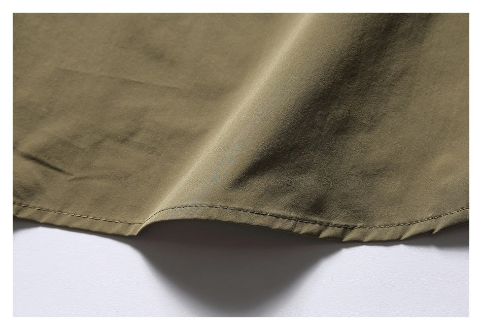 Close-up of the olive-khaki garment's curved, stitched hem against a white background.