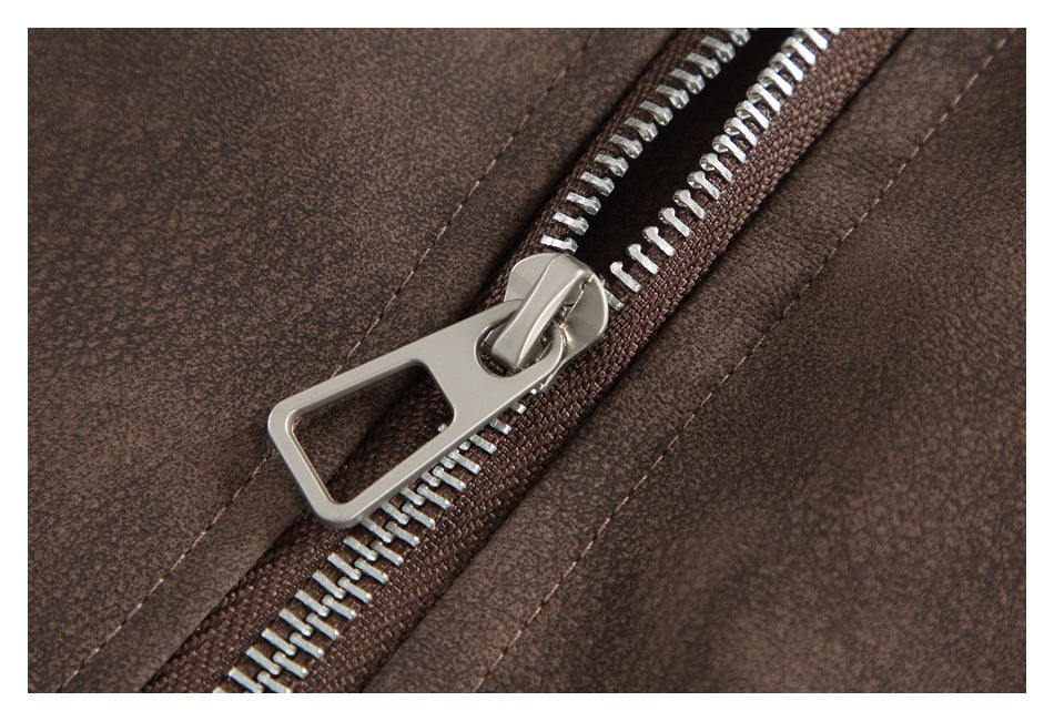Macro view of a silver zipper and pull on mottled brown jacket fabric.