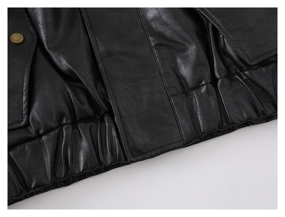 Close-up of the black jacket's gathered lower hem and stitched panels.