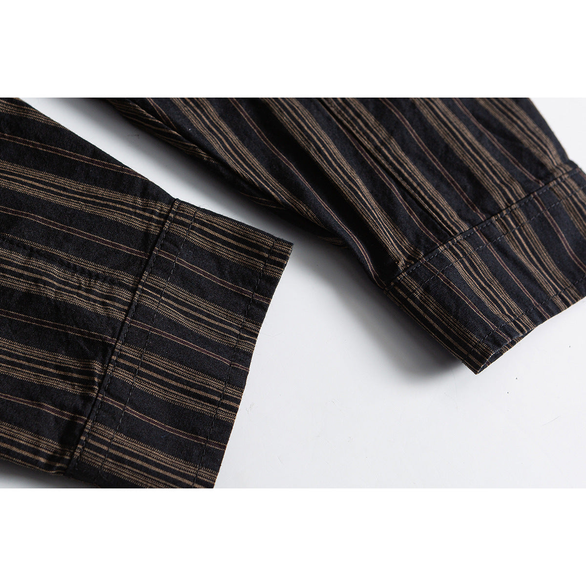 Close-up of dark charcoal shirt sleeves and cuffs with fine brown stripes.