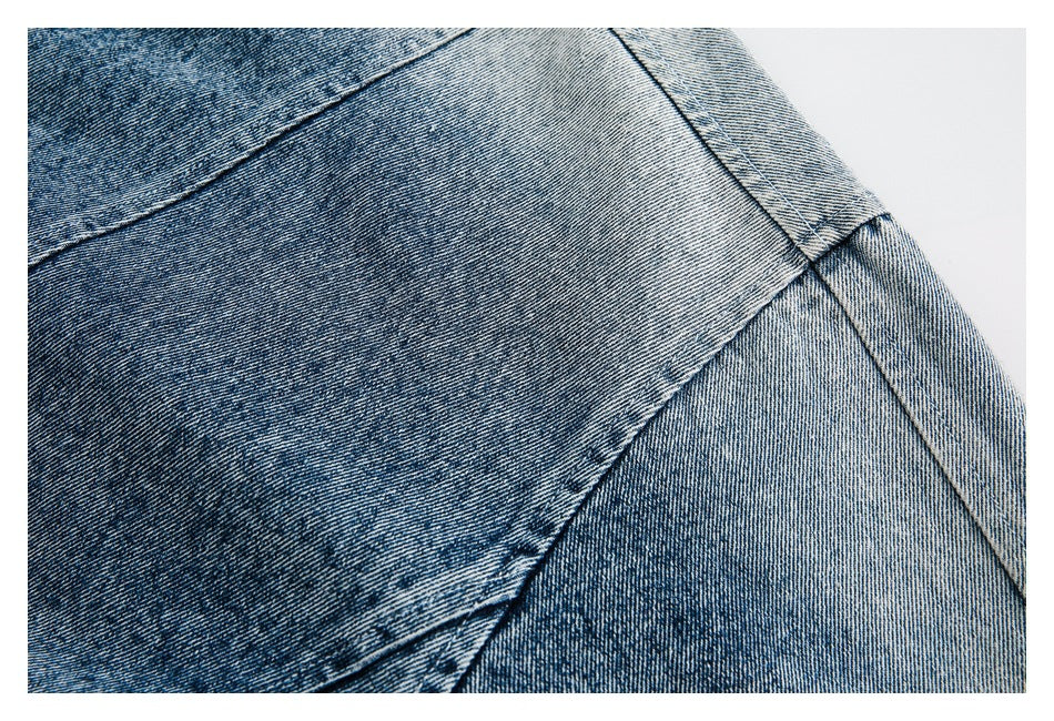 Close-up of faded blue denim with diagonal stitched seams.