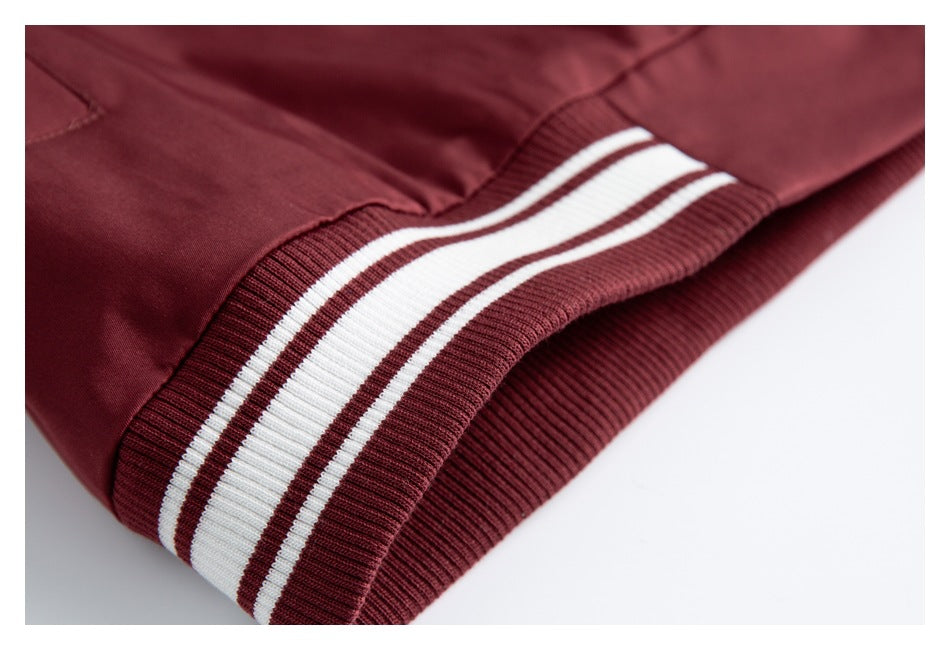 Close-up of a burgundy jacket hem with a ribbed burgundy-and-white striped band.