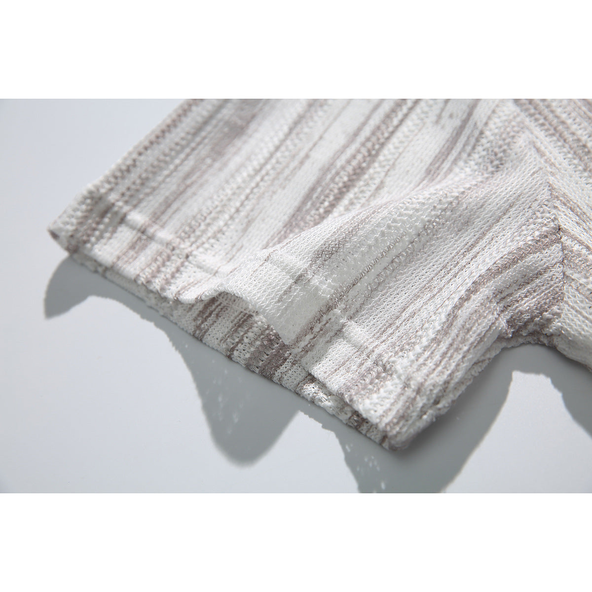 Close-up of the shirt's striped fabric and stitched folded edge.