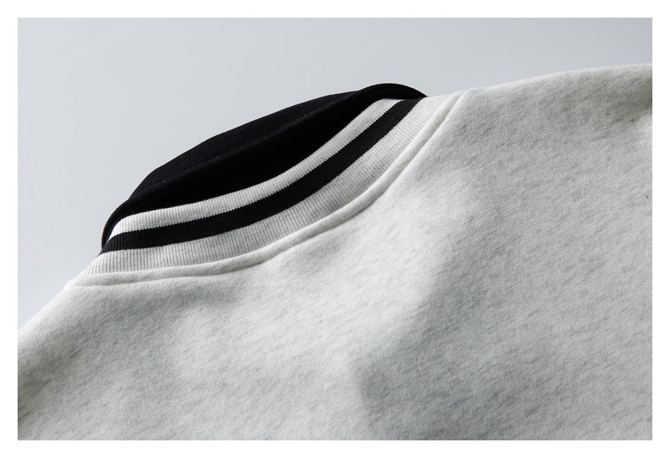 Close-up of a light gray heather garment's ribbed collar with black and white stripes.