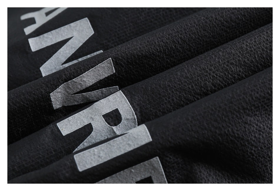 Macro view of large gray lettering on folded black textured fabric.