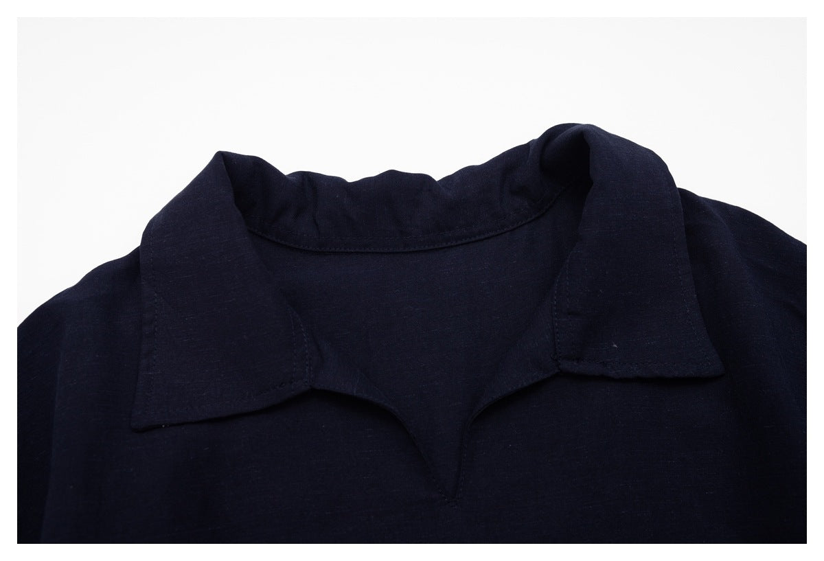 Close-up of a dark navy shirt's pointed collar and neckline against a white background.