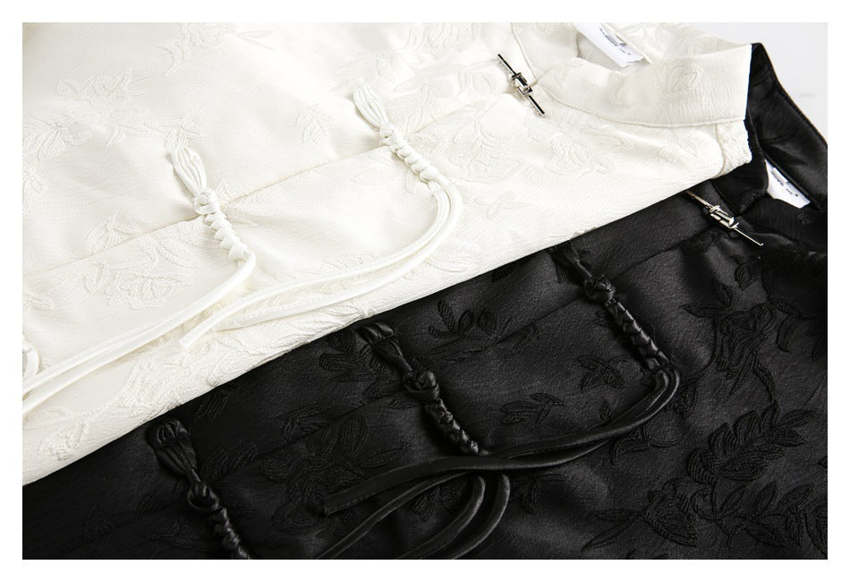 Close-up of ivory and black floral shirts showing frog closures and long looped ties.