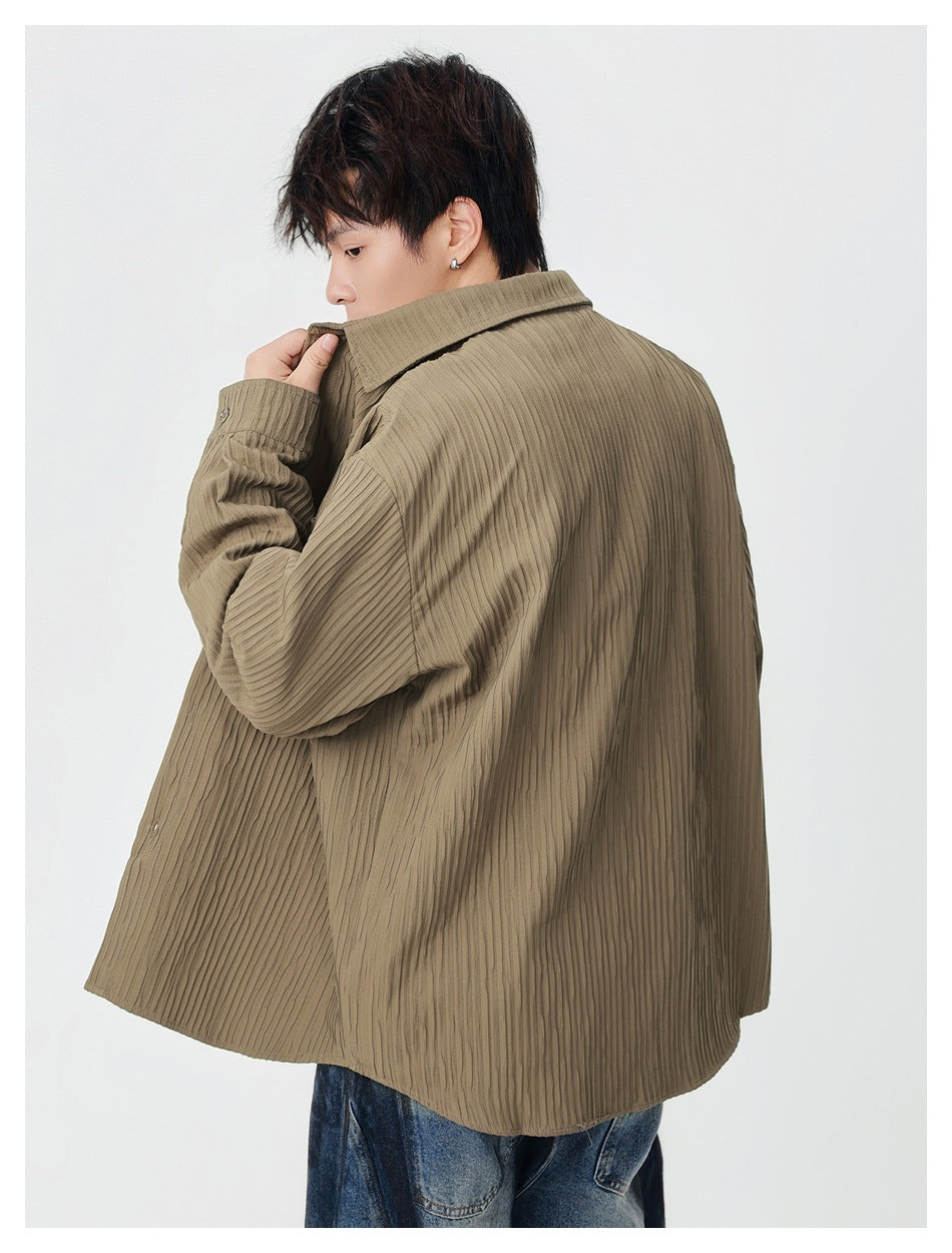 Model turned away to show the back of an olive-brown overshirt with vertical texture and a pointed collar.