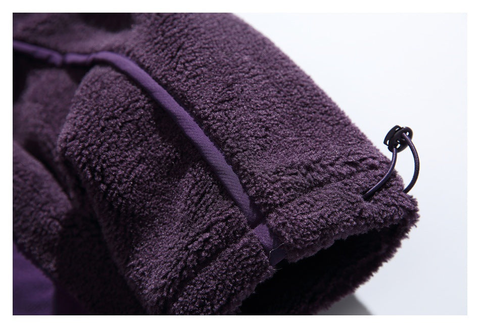 Close-up of a fleece sleeve cuff with purple piping and an adjustable dark cord toggle.