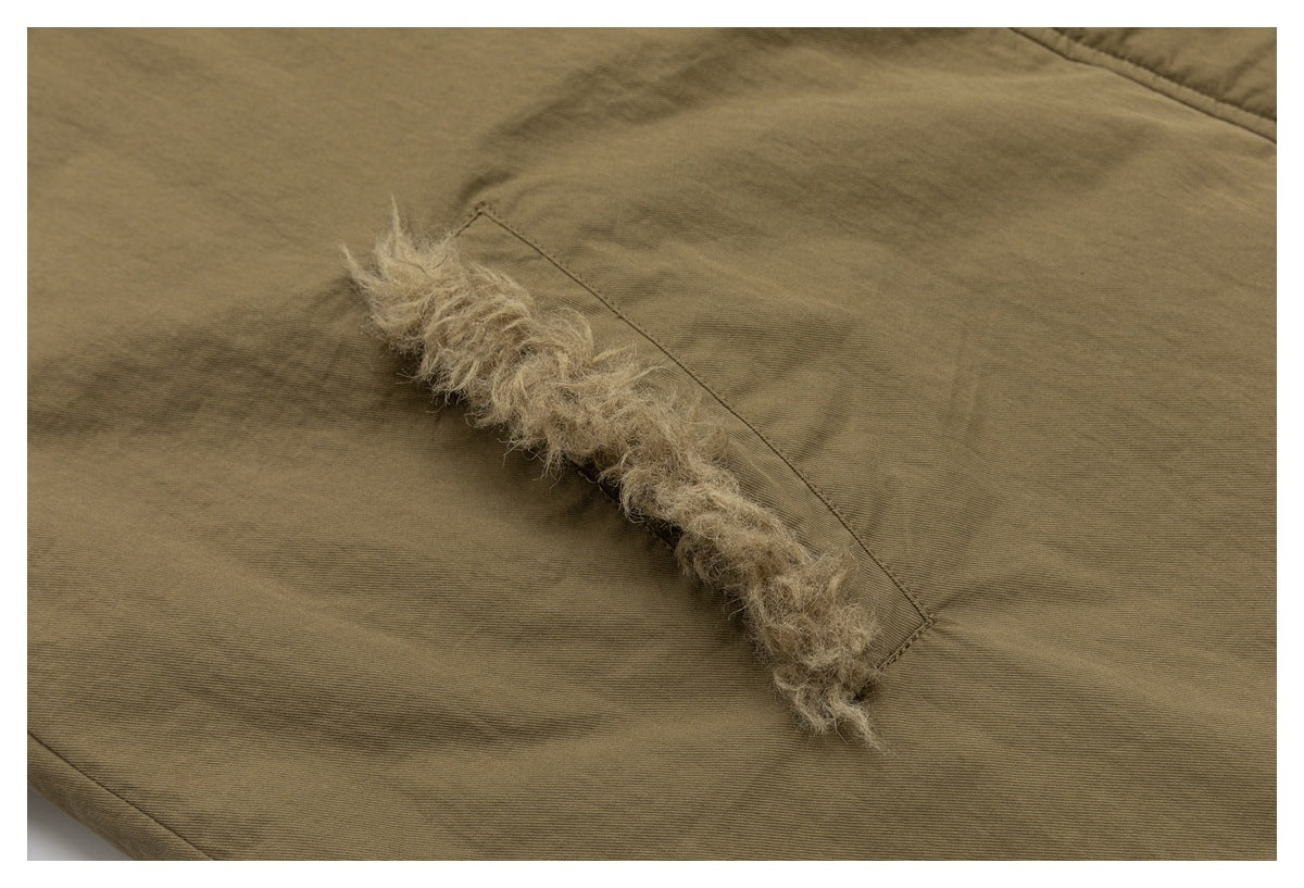 Close-up of a curved opening edged with curly tan lining on an olive-brown coat panel.