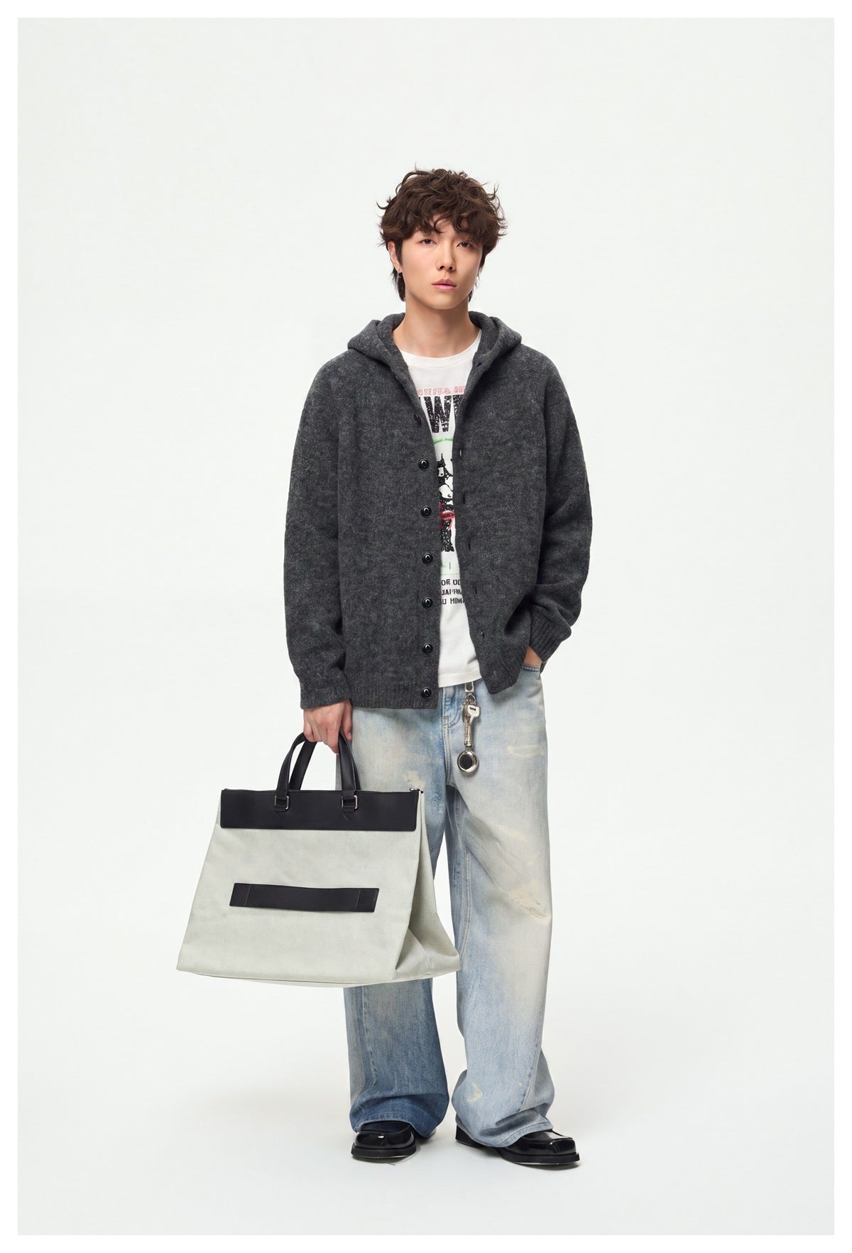 Model wearing a charcoal hooded button cardigan over a graphic T-shirt and light-wash jeans.