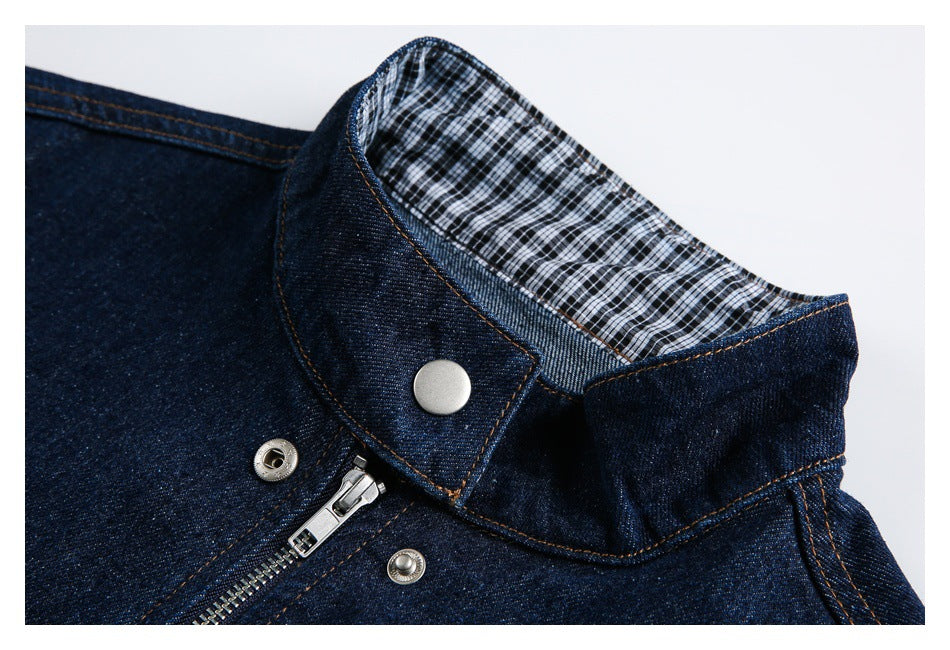 Close-up of the denim jacket collar, showing checked lining, a metal snap, and part of the zipper.