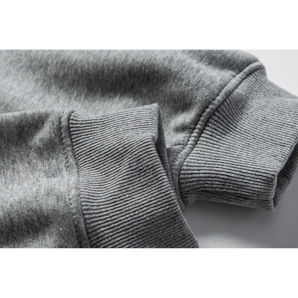 Close-up of ribbed gray hoodie cuffs and heather fabric.