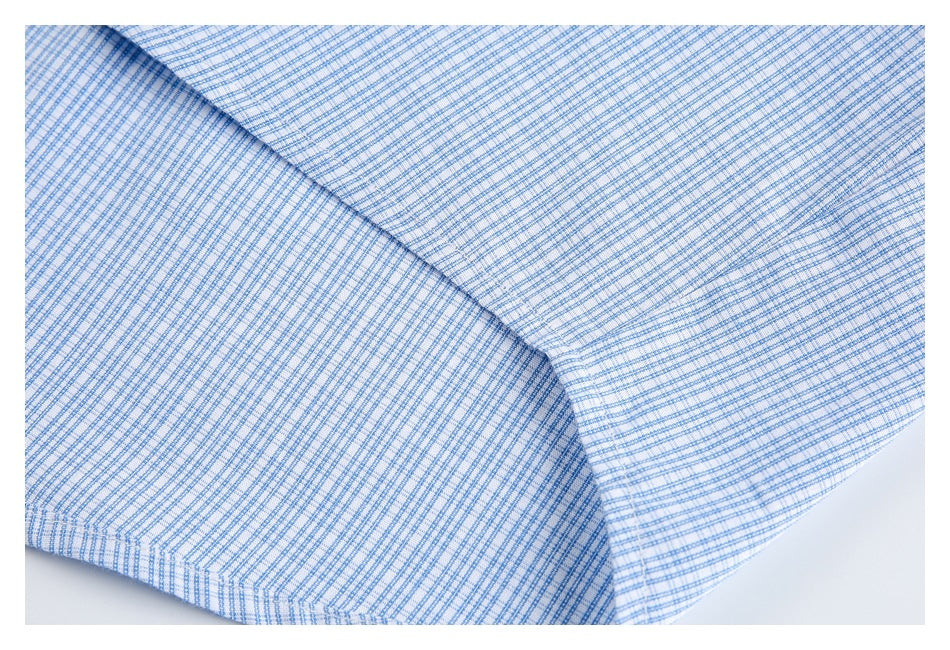 Close-up of overlapping blue-and-white check shirt fabric and a stitched seam.