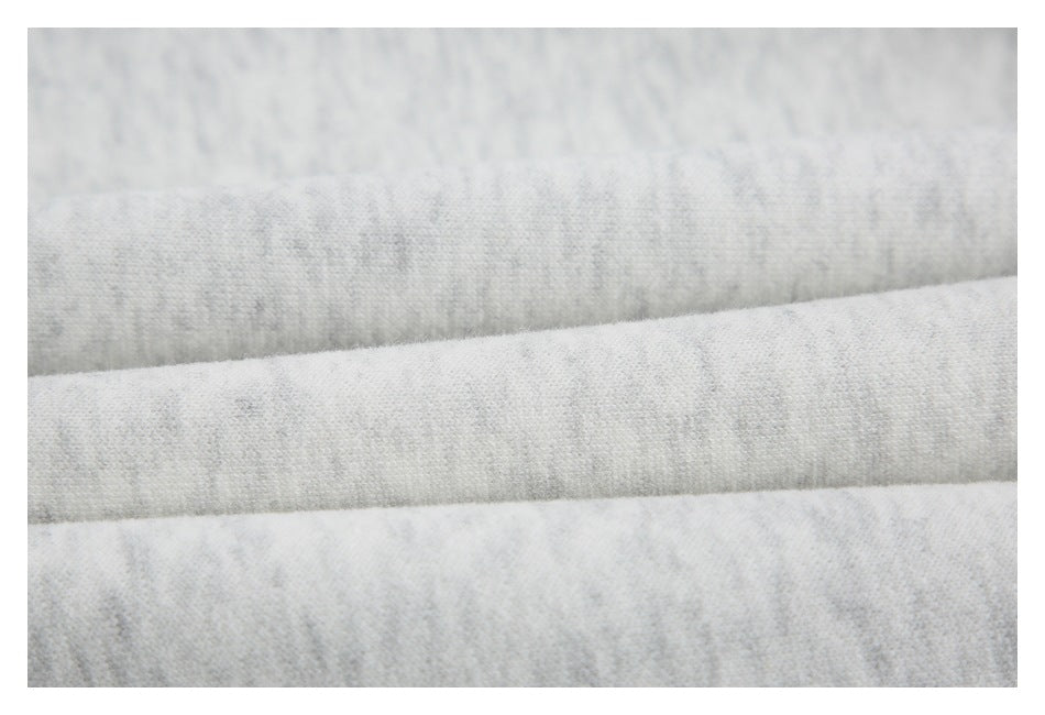 Extreme close-up of light gray marled fabric folded into soft horizontal layers.