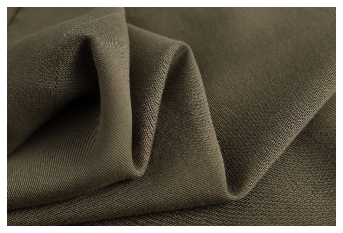 Close-up of dark olive-brown fabric with a fine diagonal weave and soft folds.
