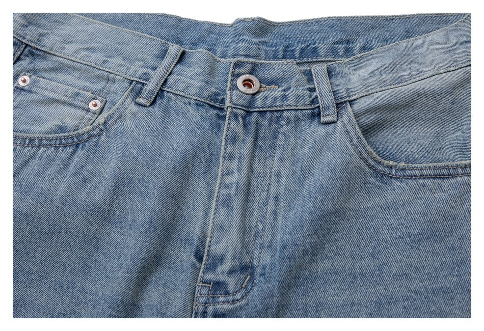 Front view of light blue washed jeans laid flat, showing the waistband, pockets and fly.