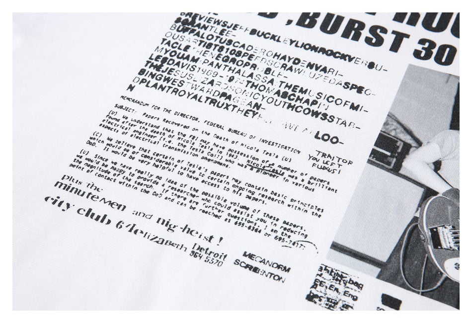 Close-up of distressed black text and small print within a large graphic on a white T-shirt.
