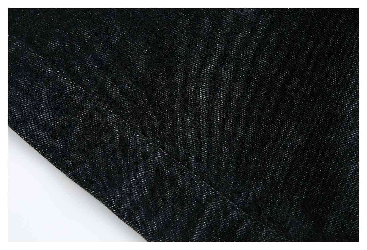 Close-up of black fabric showing a diagonal stitched seam and fine texture.
