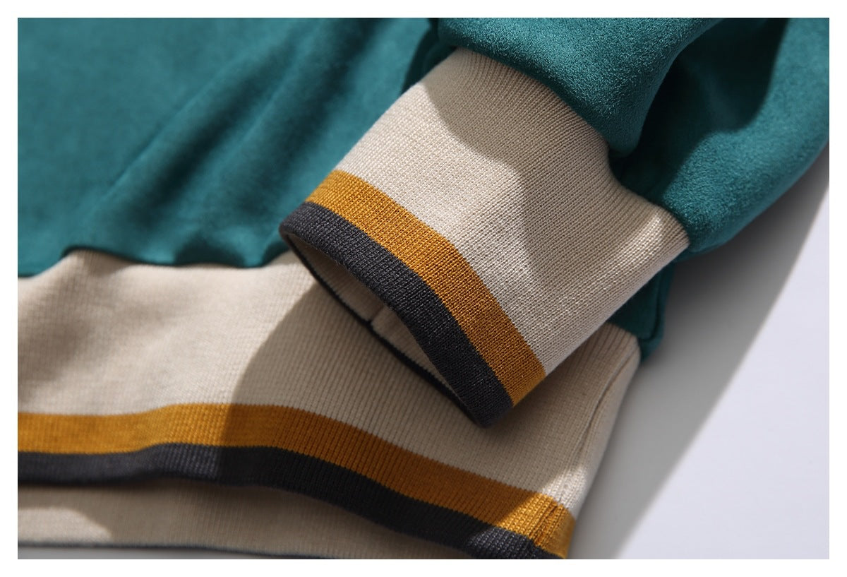 Close-up of teal sleeves and cream ribbed cuffs with mustard and charcoal stripes.