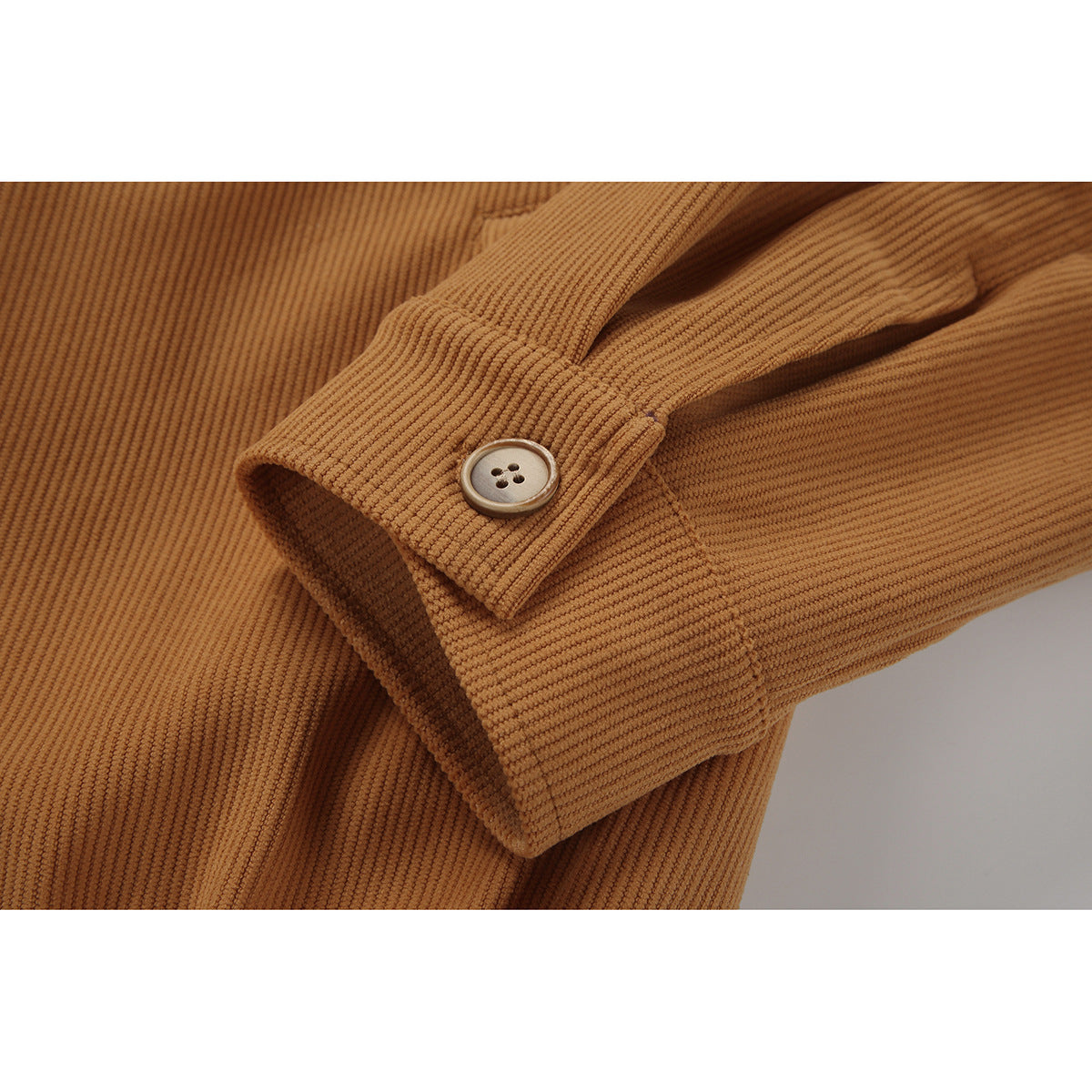 Close-up of a tan ribbed jacket sleeve cuff with a button closure.