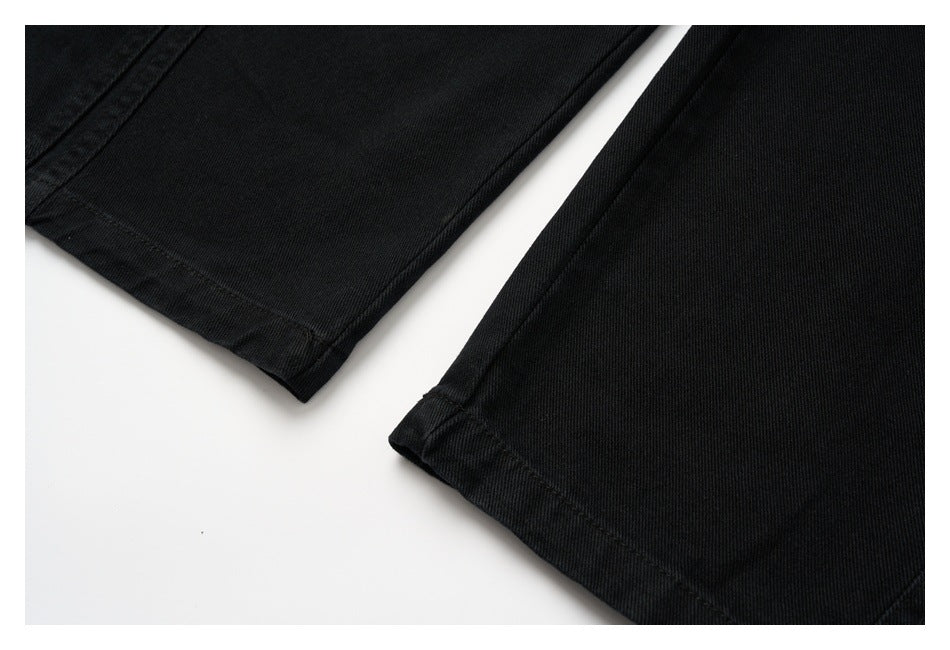 Close-up of the two straight hems of black pants on a white background.