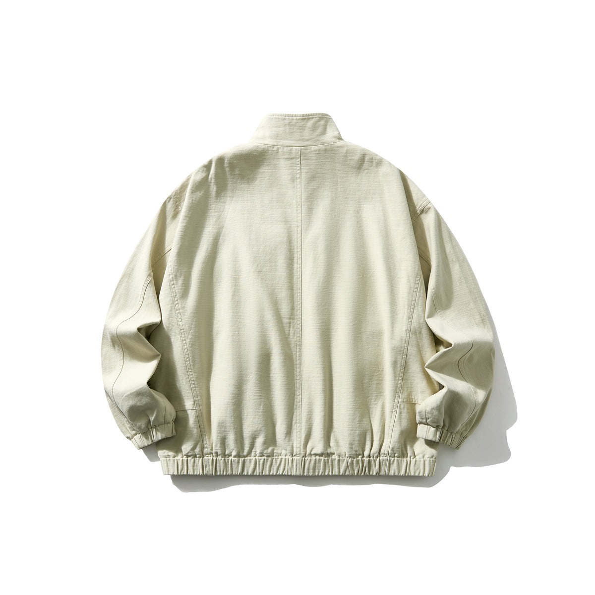 Back view of a pale beige jacket with a stand collar, long sleeves, and gathered elastic hem and cuffs.